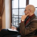 Side view of a thoughtful psychotherapist in a cozy office, holding a tablet.